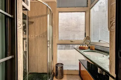 a bathroom with a shower and a sink and a window at San Calisto Suite in Rome