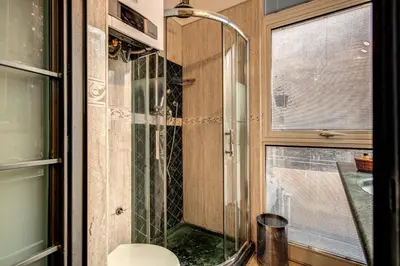 a bathroom with a shower and a toilet and a window at San Calisto Suite in Rome