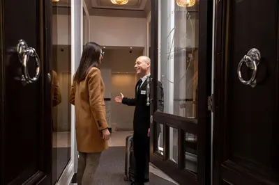 a man and a woman standing in front of a window at The Inn at the Spanish Steps Luxury Collection - Mario De' Fiori Suite in Rome
