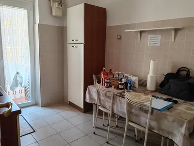a kitchen with a table with chairs and a refrigerator at Andreina a San Pietro Apartment in Rome