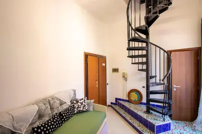 a living room with a spiral staircase and a couch at Cody's Apartment in Rome