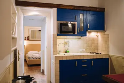 a blue kitchen with a sink and a microwave at Limani - Navona Private Apartment in Rome