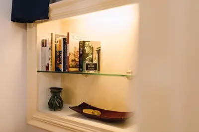 a book shelf with books and a vase on it at Limani - Navona Private Apartment in Rome