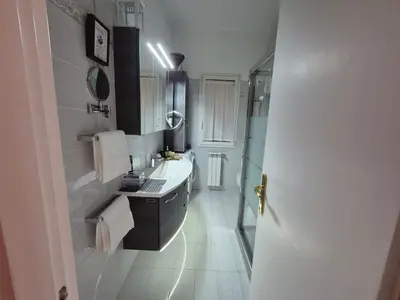 a white bathroom with a sink and a mirror at Lilli Home - Urban Garden in Rome
