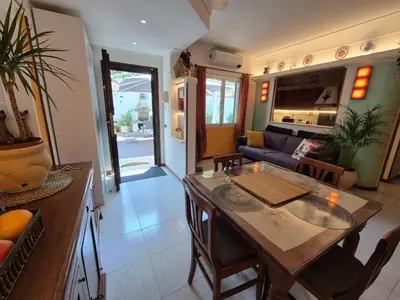 a kitchen and living room with a table and a couch at Lilli Home - Urban Garden in Rome