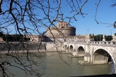 a bridge over a river with a castle in the background at Sleep In Rome Ludovisi in Rome