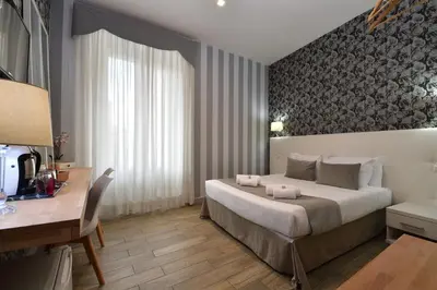 a bedroom with a large bed and a desk and a desk at Rome Vatican Inn in Rome
