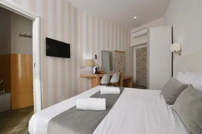 a bedroom with a large white bed and a television at Rome Vatican Inn in Rome