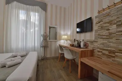 a hotel room with a bed and a desk with a television at Rome Vatican Inn in Rome