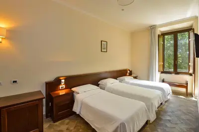 a bedroom with three beds and a window at Casa I Cappuccini in Rome
