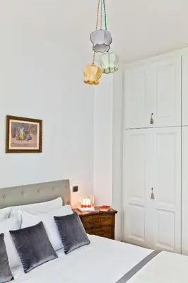 a bedroom with a white bed and a chandelier at Garibaldi Suites Piazza Di Spagna in Rome