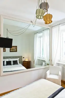 a bedroom with a bed and a mirror at Garibaldi Suites Piazza Di Spagna in Rome
