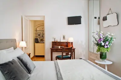 a bedroom with a bed and a desk with a vase of flowers at Garibaldi Suites Piazza Di Spagna in Rome