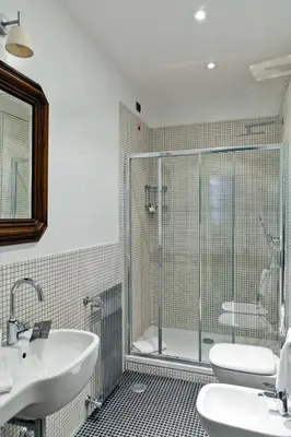 a bathroom with a glass shower and a sink at Garibaldi Suites Piazza Di Spagna in Rome