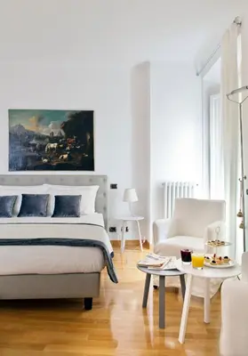 a white bedroom with a bed and a couch at Garibaldi Suites Piazza Di Spagna in Rome