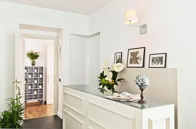 a white living room with a table with flowers on it at Garibaldi Suites Piazza Di Spagna in Rome