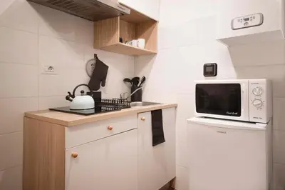 a small kitchen with a microwave and a sink at Stranamore Apartments Trastevere in Rome