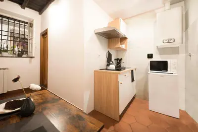 a small kitchen with a refrigerator and a microwave at Stranamore Apartments Trastevere in Rome