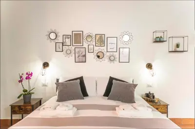 a bedroom with a white bed with pictures on the wall at Stranamore Apartments Trastevere in Rome