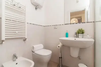 a white bathroom with a toilet and a sink at Bye Bye Roma Pantheon Suite in Rome