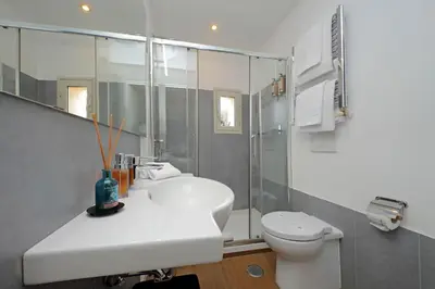 a white bathroom with a sink and a toilet at Michelangelo Charmsuite in Rome