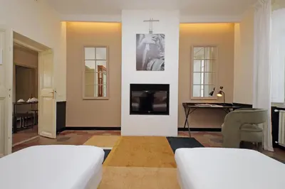 a bedroom with a bed and a living room with a tv at Michelangelo Charmsuite in Rome