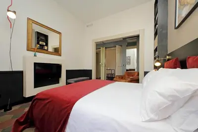 a bedroom with a large bed and a television at Michelangelo Charmsuite in Rome