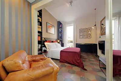 a bedroom with a bed and a couch in a room at Michelangelo Charmsuite in Rome