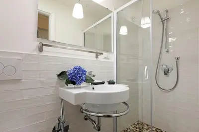 a white bathroom with a sink and a shower at RESIDENZA VITTORIA Roma in Rome