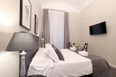 a bedroom with a white bed with a lamp and a television at RESIDENZA VITTORIA Roma in Rome