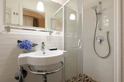 a white bathroom with a sink and a shower at RESIDENZA VITTORIA Roma in Rome