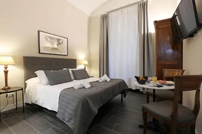 a bedroom with a bed and a table and a television at RESIDENZA VITTORIA Roma in Rome