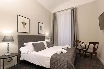 a bedroom with a bed and a table and a chair at RESIDENZA VITTORIA Roma in Rome