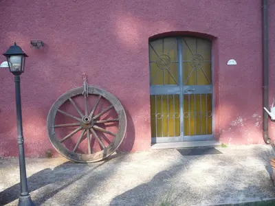 a pink building with a large wheel next to a door at Il Baffetto B&B in Rome