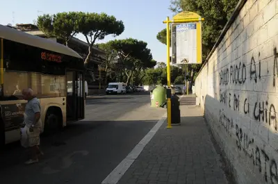 a man standing next to a bus on a street at Il Baffetto B&B in Rome
