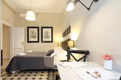 a bedroom with a bed and a desk with a table at Residenza Mazzini in Rome