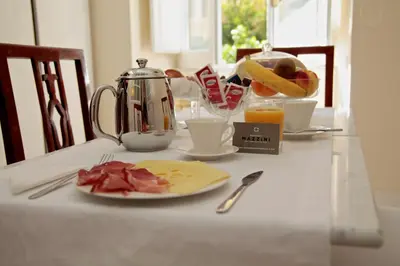 a table with a plate of food and a kettle at Residenza Mazzini in Rome