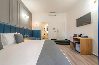 a hotel room with a large white bed and a chair at Crescenzio 74 Boutique Guest House by Ghor in Rome