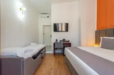 a bedroom with a bed with white sheets and a window at Crescenzio 74 Boutique Guest House by Ghor in Rome