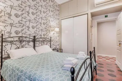 a bedroom with a bed with a floral wallpaper at B&B Trastevere 94 in Rome