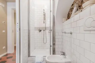 a white bathroom with a shower and a sink at B&B Trastevere 94 in Rome