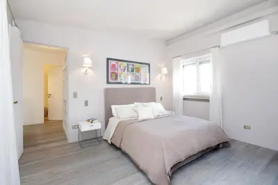 a white bedroom with a bed and a window at Crispi Luxury Apartments - My Extra Home in Rome
