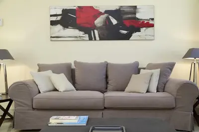 a living room with a couch and a painting on the wall at Crispi Luxury Apartments - My Extra Home in Rome