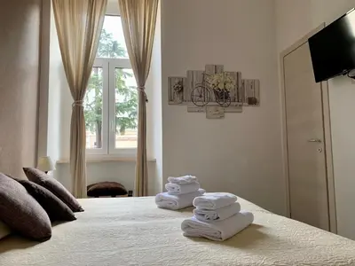 a bedroom with towels on a bed with a window at Guest House Casa Vicenza in Rome