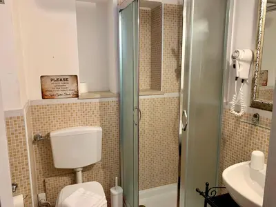 a small bathroom with a toilet and a shower at Guest House Casa Vicenza in Rome