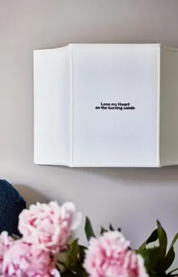 a book sitting on a shelf with pink flowers at HOTEL VITE - By Naman Hotellerie in Rome