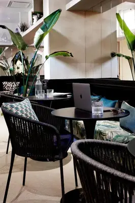 a cafe with tables and chairs with a laptop on it at HOTEL VITE - By Naman Hotellerie in Rome