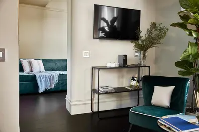 a living room with a green chair and a couch at HOTEL VITE - By Naman Hotellerie in Rome