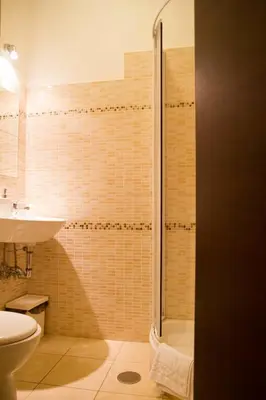 a bathroom with a shower and a toilet and a sink at Mosaic Central Guest House in Rome