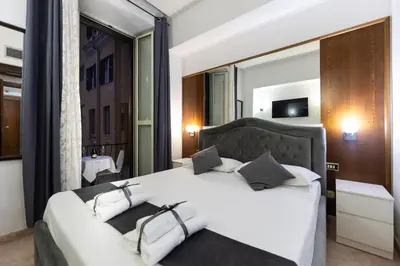 a bedroom with a large white bed with two pillows at Hotel Max in Rome